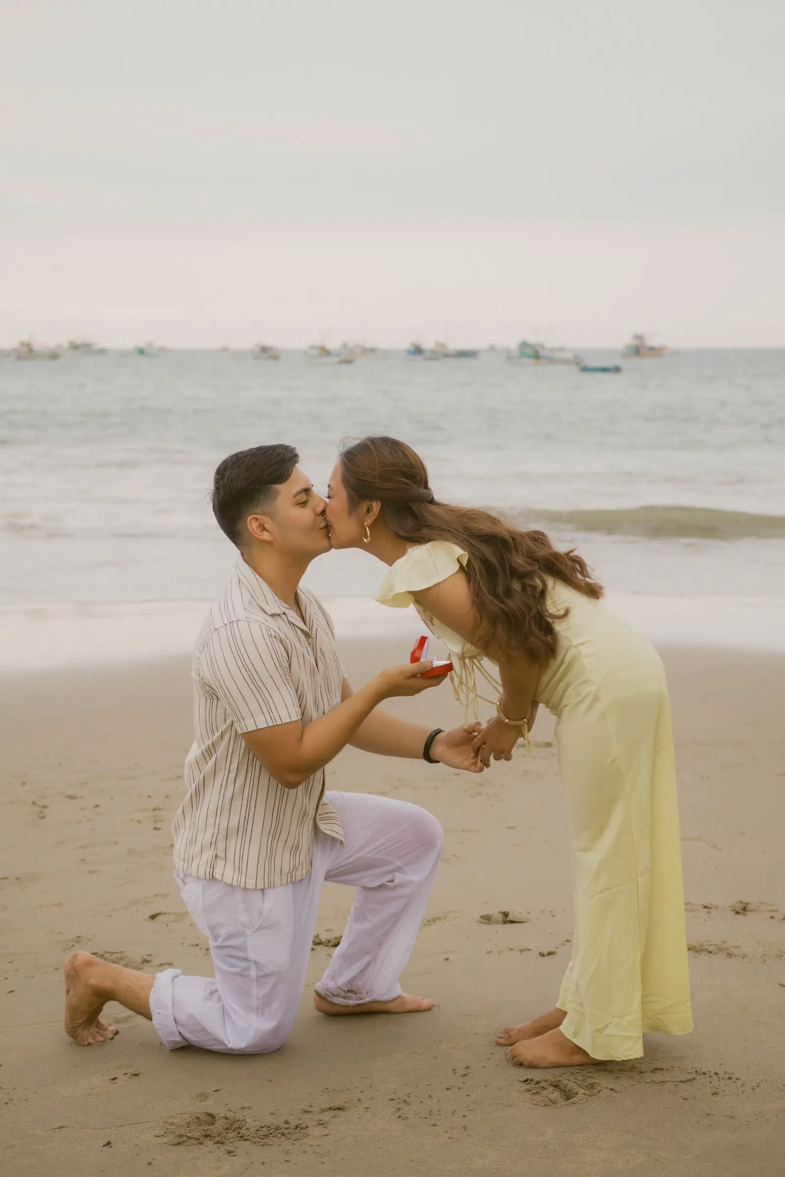Propuesta con beso en la playa, vestido amarillo
