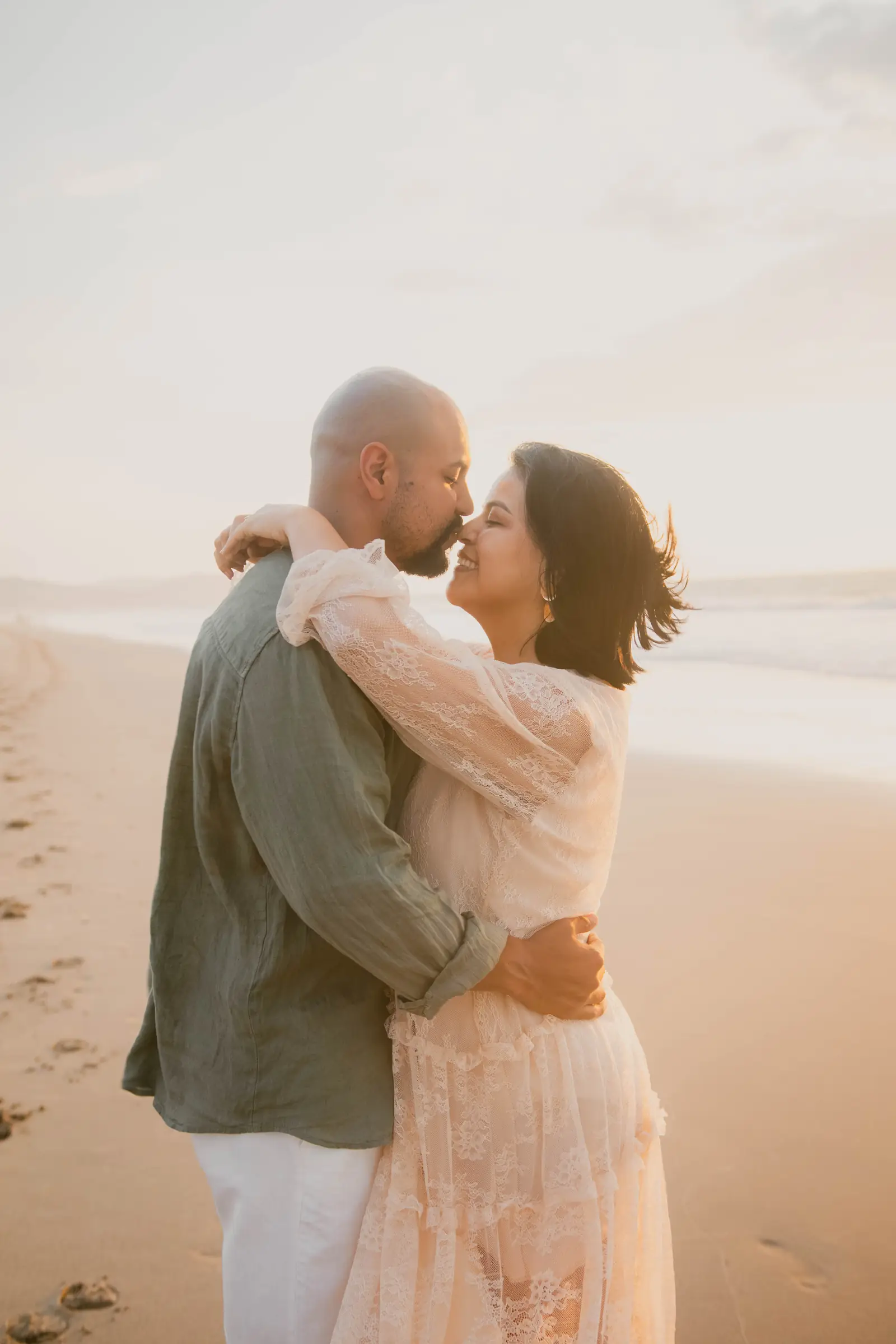 Pareja abrazada con las narices juntas en la playa