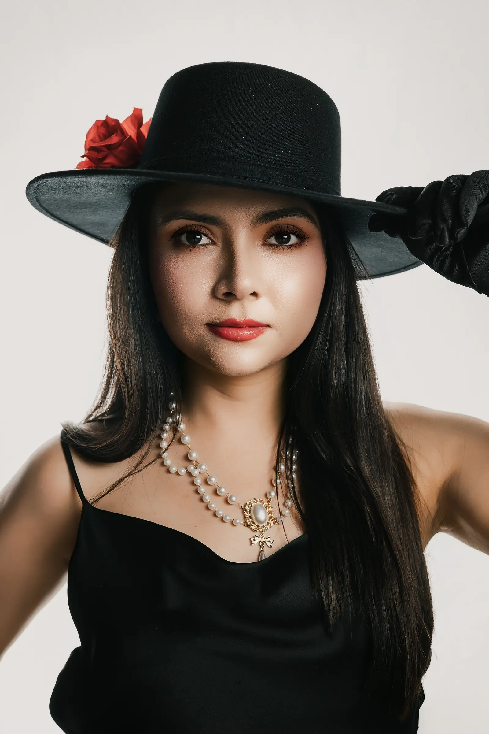 Retrato de estudio con sombrero negro y una rosa